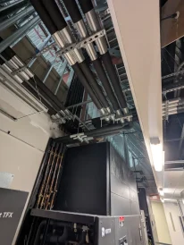 Overhead view of mechanical piping and insulation connected to large cooling units in a facility.