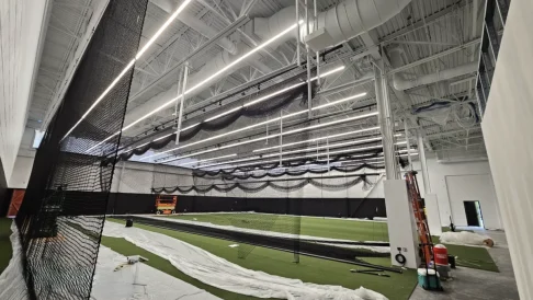 Commercial construction project with exposed piping, steel framing, and mechanical systems