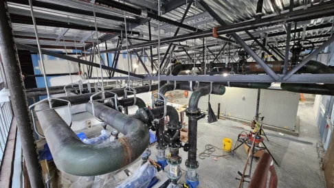 Indoor commercial construction site with ceiling lights and protective netting